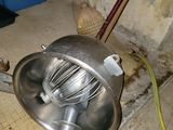 a metal bowl with a whisk in it on the floor