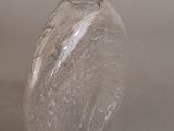 a clear glass vase with a white lid on a table