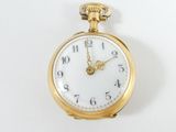 a gold pocket watch with a white face on a white surface