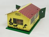 a small yellow house with a red roof on a green base