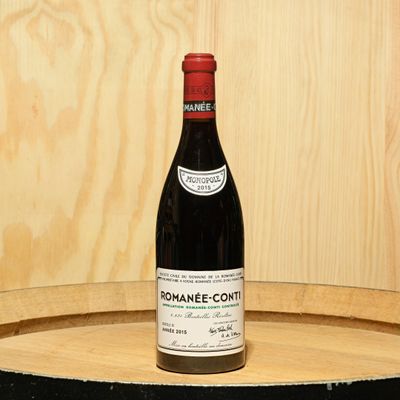 a bottle of wine sitting on top of a barrel