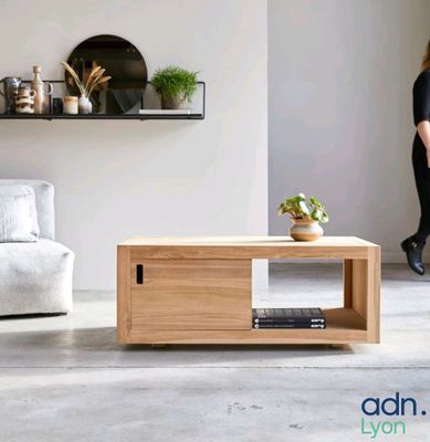 a woman standing in a living room with a coffee table