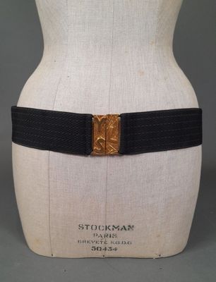 a close up of a mannequin torso with a black belt and gold buckle