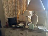 a lamp that is on top of a dresser in a room