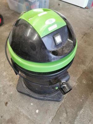 a green and black vacuum cleaner sitting on the floor