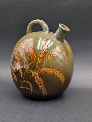 a vase with a painting on it sitting on a table