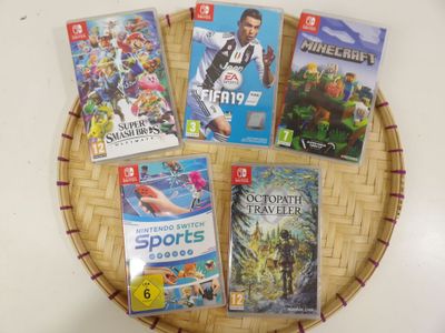 Plusieurs jeux vidéo sont posés sur un plateau en osier posé sur une table