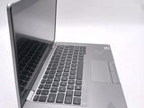 a silver laptop with a black keyboard on a white table