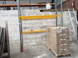 boxes are stacked on pallets in a warehouse with a ladder