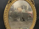 a mirror hanging on the wall with a city in the background
