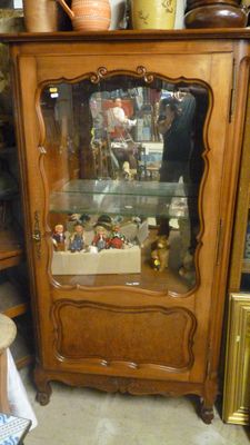 un meuble en bois avec une porte en verre dans le coin d'une pièce