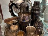un plateau en argent sur lequel sont posées des tasses en argent et un pichet en argent