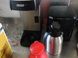 une cafetière et une bouilloire posées sur le plan de travail de la cuisine