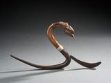 une sculpture représentant un serpent avec une longue queue sur le dos