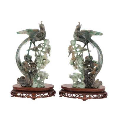 pair of green and white sculptures of birds and flowers on wooden bases