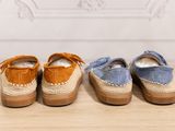 three pairs of shoes sitting on top of a wooden table