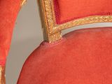 a red and gold chair with a gold frame on it