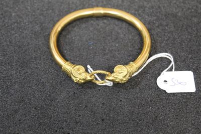 a close up of a gold bracelet with a tag attached to it