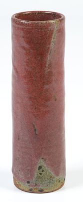 a red vase that is sitting on a white surface