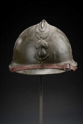 an old helmet on a metal stand with a black background