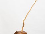 a small wooden vase with a branch sticking out of it