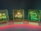 three glass blocks that have neon lights on them