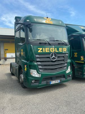 two green trucks parked next to each other in a parking lot