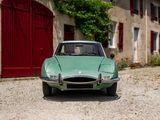 a green car that is parked in front of a building
