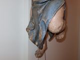 a statue of a person hanging on a wall