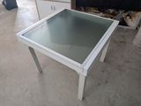 une table en verre avec un plateau en verre au milieu d'une pièce