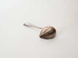 a silver spoon with a metal handle on a white surface