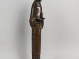 a bronze statue of a woman with a bird on her head