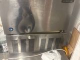 a cat that is sitting on top of a stainless steel oven