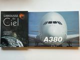 deux livres posés sur une table, avec un avion en arrière-plan