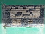 a metal plaque on the side of a green wall