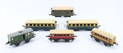 five toy trains sitting next to each other on a white surface