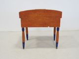 a small wooden table with blue legs on a white floor