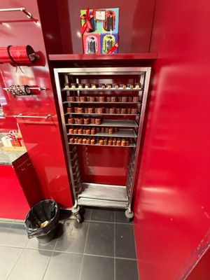 un mur rouge dans un magasin, avec une étagère remplie de bocaux