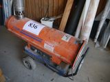 an orange gas heater sitting on a cart in a garage