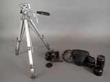 a tripod with a camera and other items on a table