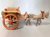 a toy horse pulling a wooden cart with a man on it