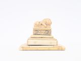 a small statue of a lion on top of a pile of books