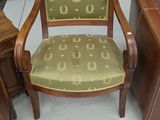 une chaise en bois avec une assise rembourrée verte dans une pièce