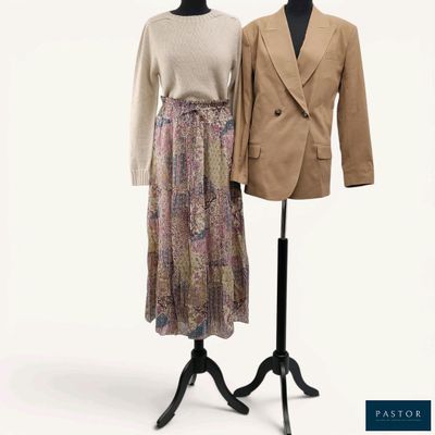 two dresses on a mannequin stand next to each other
