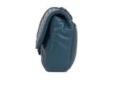 the small blue bag is sitting on a white surface