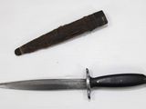 a knife that is laying next to a knife on a table
