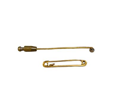 pair of brass safety pins on a white background