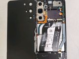 the back of a cell phone with a broken battery and a hard drive