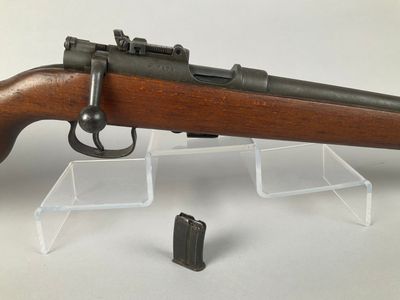 an old rifle with a wooden barrel and a magazine holder