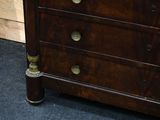 a wooden chest of drawers with a clock on top of it